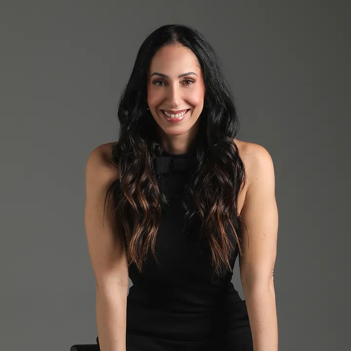 Dra. Denise de Carvalho sorrindo, em foto de estúdio